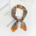 Detailed view of a stylish blue and brown geometric plaid square silk scarf used as neckwear. - Orange Border Cartoon Plaid
