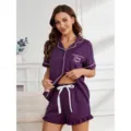Gedetailleerd overzicht van paarse pyjamaset met witte bies en borstzakprint. - S / Top en Broek / TR88-Paars