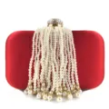 Close-up view of red satin evening bag showcasing cascading pearl tassel strands and crystal clasp. - Red
