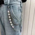 Close-up detail of multi-layer pearl and metal pants chain accessory styled on denim jeans. - Pearl & Chain Patchwork Trousers Chain K0123