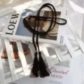 Detailaufnahme eines dunkelbraunen geflochtenen Quasten-Gürtels im vintage Boho-Stil. - Braune Baumwollseil-Taillenketten mit Quasten