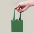Detailansicht der grünen tragbaren Schmuckschachtel mit Schleifengriff für Ringe und Ketten. - Ausziehbarer Tragestil / Grüne Tragetasche (11*11*4.5cm)