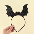 Detailaufnahme des schwarzen Glitzer Fledermausflügel Haarreifs für gruselige Party Kostüme. - Großes Pailletten Fledermaus Stirnband