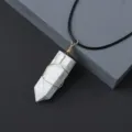 Detail view of natural crystal hexagonal column pendant wrapped in gold wire with black cord. - Howlite / Pendant