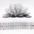 Closeup detail view of white paper garland and hanging decoration for party and wedding styling. - Gray