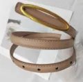 Cintura sottile in pelle con fibbia ovale color cammello, scatto di dettaglio per moda donna. - Beige