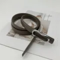 Gros plan détaillé d'une ceinture en cuir minimaliste pour femme avec boucle argentée élégante. - Gris Avec Boucle Argentée