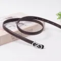 Detailed close-up shot of a slim dark brown leather women's belt with a silver metal buckle. - 100cm / 1.5 Coffee