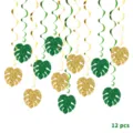 Detail view of Hawaiian party hanging swirl decorations with glittering green and gold monstera leaves. - 12-Piece Set