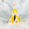 Detail view of a pink birthday party hat with gold chevron pattern and fluffy pom-pom top. - Ripple Stars on Pink (Pom-pom Ball)