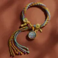 Handgewebtes tibetisches mehrfarbiges Kordelarmband mit Thangka-Anhänger und goldenen Quasten. - Akasagarbha [Samsara Handseil]