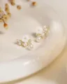 Dettaglio orecchini perle e fiori delicati, montatura dorata, fiori bianchi e cristalli luminosi. - Perla di Conchiglia di Fiore / Oro