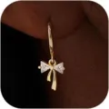 Nahaufnahme Detail von goldenen Creolen mit funkelndem Zirkonia Schleifen-Anhänger glänzend. - 14k / e2234 Gold Paar