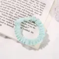 Detail view of mint green mesh hair scrunchie, soft elastic fabric hair tie for cute daily styling. - Green