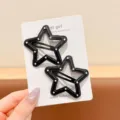Detail shot of black and white polka dot star leather hair clips set on display card. - All Black Star 2-Piece Set