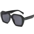 Modische schwarze geometrische Sonnenbrille mit dickem Rahmen und goldenen Akzenten. - Schwarzer Rahmen Graue Gläser