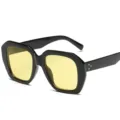 Stylische schwarze Sonnenbrille mit gelben Gläsern und trendigen Nietendetails im Retro-Look. - Schwarzer Rahmen Gelbe Gläser
