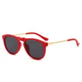 Stylish round frame sunglasses with red rims and gold temples for a chic vintage look. - Red Frame Grey Lens