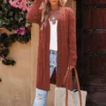 Close-up detail of women's long knitted cardigan sweater featuring buttons and pockets. - Brick Red