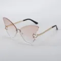 Close-up detail of trendy butterfly rimless sunglasses with gradient pink lenses and gold chain temples. - Gradient Pink