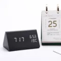 Wooden triangular LED alarm clock detail view with digital time, temperature and humidity. - Black Wood White Light