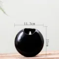 Detail shot of black ceramic wall hanging planter vase, spherical shape, minimalist 11cm. - Black