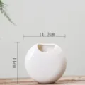 Detail view of white ceramic wall hanging flower pot, minimalist design for succulent plants. - White