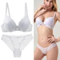 Detailed view of the white lace bra and panty lingerie set with cross straps and floral pattern. - White