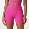High-waisted pink athletic yoga shorts, detail view showcasing form-fitting design and stitching. - S / Bottoms / Electric Fuchsia