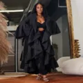 Detailed view of women's stylish solid color ruffled patchwork flared sleeve long trench coat. - S / Black