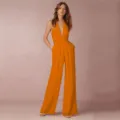 Detail view of the elegant deep V-neck halter wide-leg jumpsuit, stylish banquet wear. - S / Orange