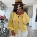 Detalle de cárdigan de punto, suéter amarillo con lazos elegante, textura suave y cómoda. - S / Amarillo