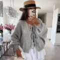 Detalle del cárdigan de punto gris elegante con lazos frontales y mangas abullonadas chic. - S / Gris