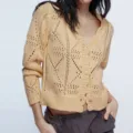 Detailed view of the women's yellow V-neck knit cardigan sweater featuring hollow-out patterns. - S / Tops / Apricot