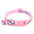 Pink cat collar detail shot featuring cute bubble print, adjustable buckle and hanging bell. - Pink