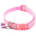 Close up view of the pink pet collar featuring cute paw patterns and a shiny bell accessory. - Pink