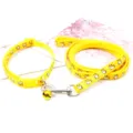 Gros plan sur le collier et la laisse jaune motif Shiba Inu mignon avec clochette, détails en métal. - Jaune