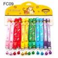 Detailed view of colorful printed pet collars with bells and cute footprint patterns. - FC09