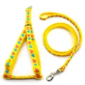 Yellow pet leash and harness detail showing lovely heart patterns and metal hardware. - Yellow