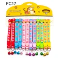 Colorful pet collar detail showing quick-release buckle, metal D-ring and hanging bell. - FC17