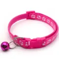 Close up view of the pink pet collar featuring cute white paw prints and metallic bell. - Rose Red