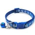 Blue pet collar detail showing white paw print pattern, plastic buckle, and shiny blue bell. - Blue