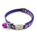 Detailed view of purple nylon pet cat collar with cute white paw print pattern and bell. - Purple