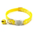 Close-up detail of yellow pet collar with white paw print, bell, and safety buckle. - Yellow