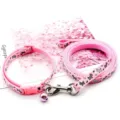 Pink pet leash and collar set detail, featuring cute dog patterns and a lovely pink bell. - Pink