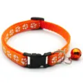 Détail de collier pour animal orange avec empreintes de pattes, boucle et petite cloche. - Orange
