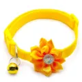 Detailed close-up of the bright yellow pet collar featuring a ribbon flower and bell. - Yellow