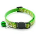 Green pet collar detail showing white paw print pattern, adjustable buckle and shiny bell. - Light Green