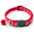 Red pet collar close-up, paw print pattern, metal D-ring, and red jingle bell. - Red