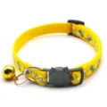 Yellow pet collar detail view featuring cute blue bone print, black cat buckle and gold bell. - Yellow